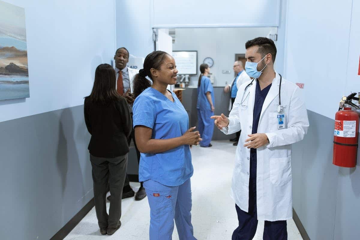 Agent de service hospitalier aidant une personne âgée en maison de retraite
